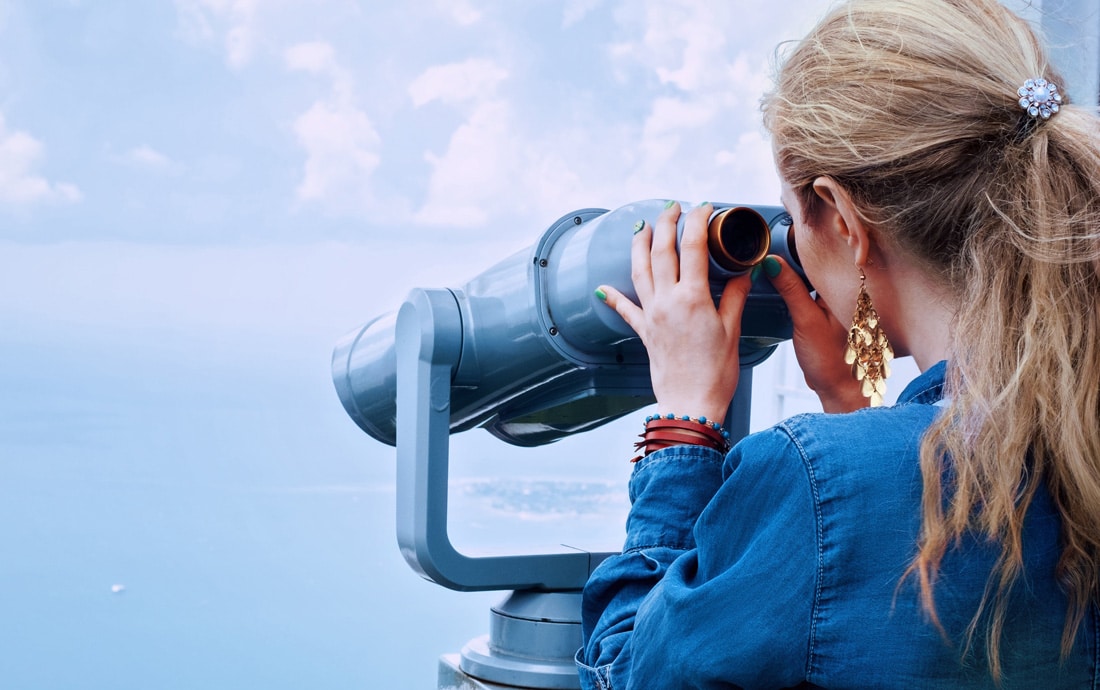 Frau hält Ausschau mit Fernglas